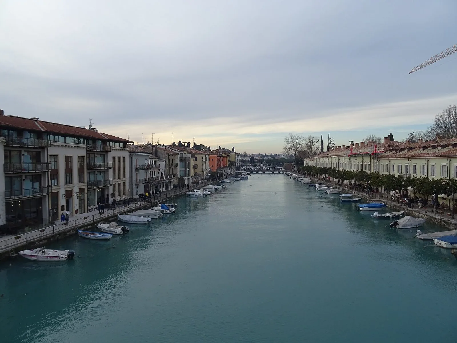 Le mura veneziane di Peschiera del Garda in una giornata d'autunno, con l'acqua del canale calma e luce dorata