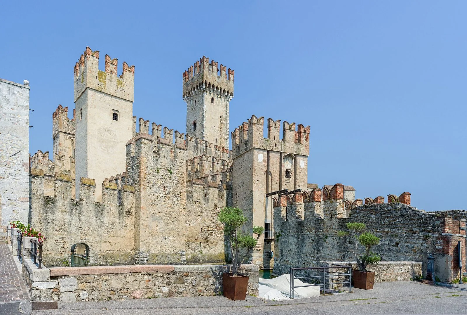 Il Castello Scaligero di Sirmione visto dal lago, con le torri merlate che si specchiano nell'acqua